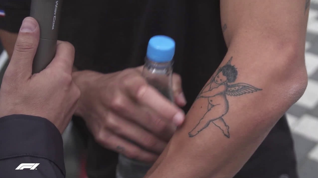 Mclaren driver Daniel Ricciardo of Australia shows a tattoo on his