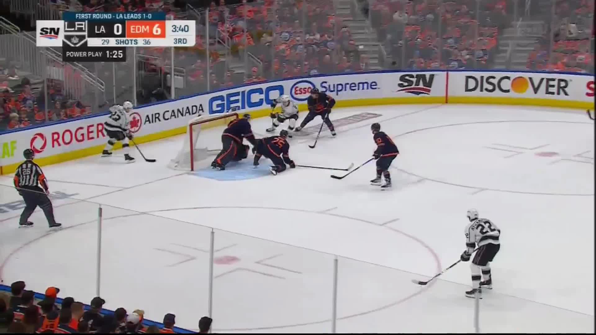 A Bunch Of Oilers Reaching For The Puck At A Similar Time