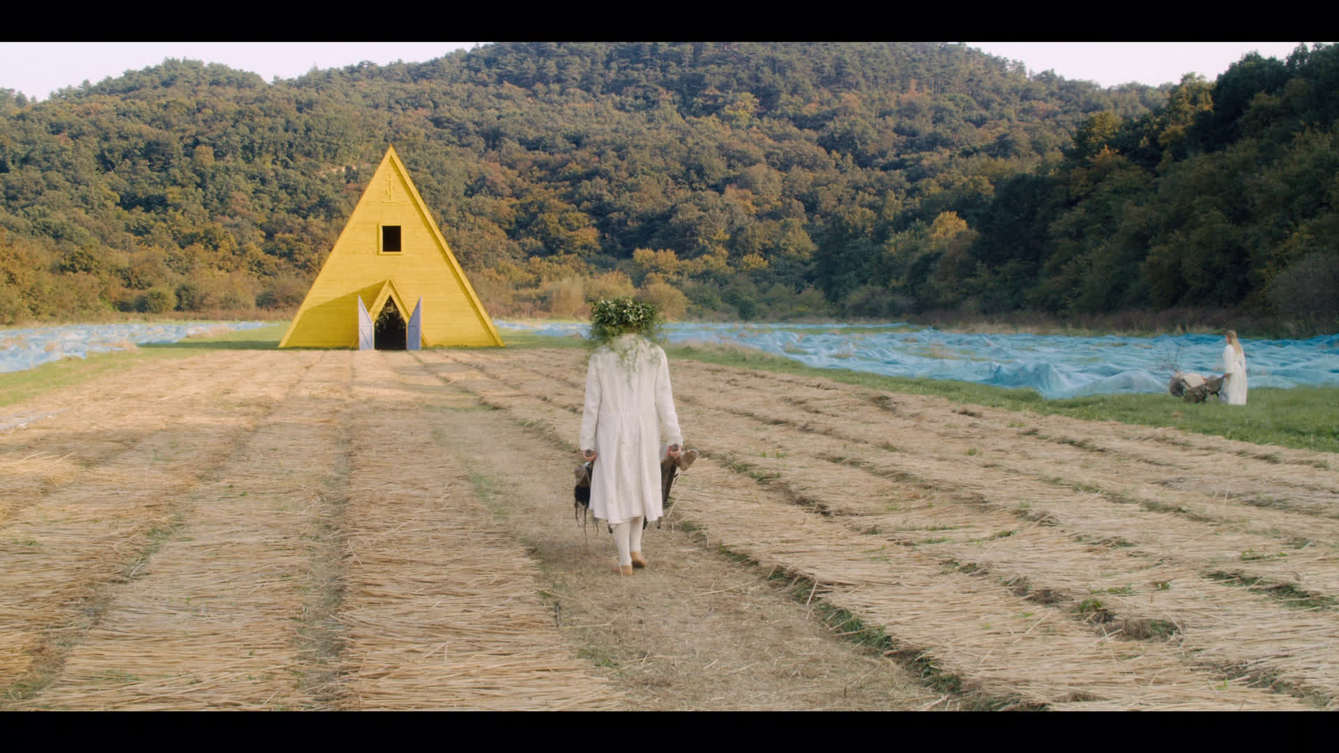 Midsommar – dead Connie being pushed to the temple in a wheelbarrow